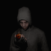 a man in a hoodie is holding an apple