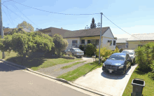 a blue mercedes is parked on the driveway in front of a house