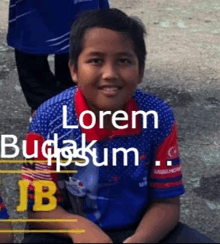 a boy wearing a blue and red shirt with the words lorem budakum jb on it