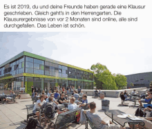 a group of people sitting outside a building that says bistro stadtmitte on it