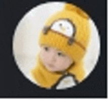 a baby wearing a yellow knitted hat with a penguin on it .