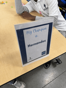 a child sits at a table with a sign that says " my champion is hernandez "