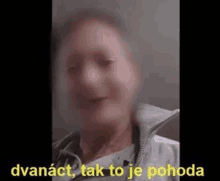 a blurry picture of a man 's face with the words dvanact , tak to je pohoda in yellow letters .