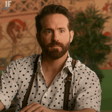 a man with a beard is wearing a polka dot shirt with suspenders