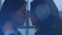 two women are kissing each other in a dark room