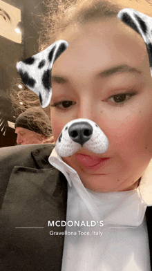 a woman is wearing a dalmatian dog face filter from mcdonald 's gravellona toce italy