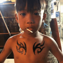 a young boy with a cigarette in his mouth has a tattoo on his chest