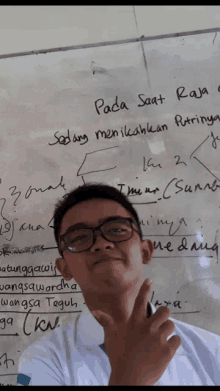 a young man stands in front of a whiteboard that says pada saat raja sedang menikahkan putrinya