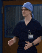 a man wearing scrubs and a hat with a name tag that says ' surgeon ' on it