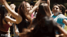 a group of girls are dancing in a circle with their arms in the air