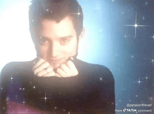 a man in a black turtleneck is surrounded by stars on a blue background