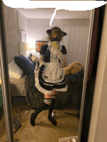 a person in a maid costume is taking a selfie in a mirror