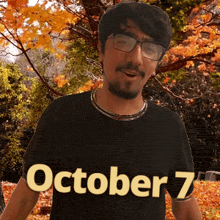 a man wearing glasses and a black shirt with october 7 written on it