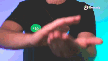 a man wearing a black shirt with a green sticker that says bonusly on it