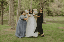 a bride and her two bridesmaids posing for a picture