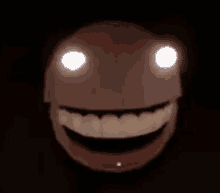 a smiling face with glowing eyes and teeth in the dark