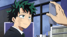 a person is taking a picture of a boy in a suit and tie with a cell phone .