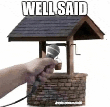 a person is holding a microphone in front of a well that says `` well said '' .