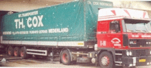 a red and green truck with the word cox on it