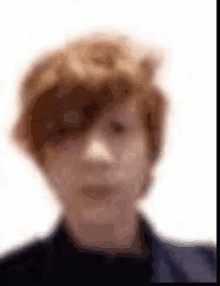 a blurry picture of a young man 's face with red hair .