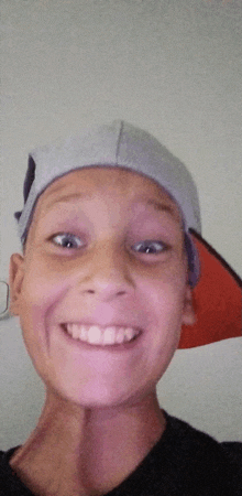 a young boy wearing a baseball cap and smiling