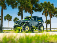 a jeep is parked in front of palm trees