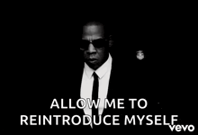 a black and white photo of a man wearing sunglasses and a suit says allow me to reintroduce myself