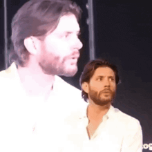 a man with a beard is standing next to another man with a beard .