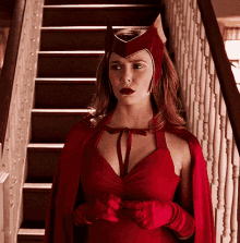 a woman in a scarlet witch costume is standing in front of a set of stairs