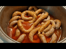 a pot full of sausages in a sauce