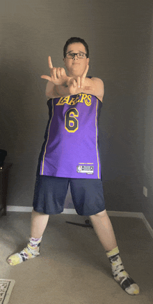 a young boy wearing a purple lakers jersey and shorts