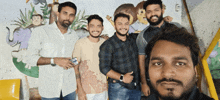 a group of men are posing for a picture in front of a wall with animals on it