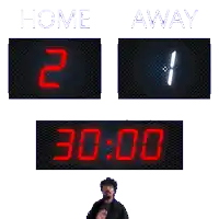 a man stands in front of a scoreboard that reads home 2 away 1