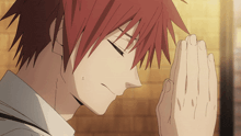 a man with red hair has his hands folded in prayer