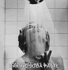 a black and white photo of a man taking a shower with baking soda and paste .