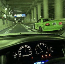 a green car is driving down a highway with a tachometer that says rpm at the bottom