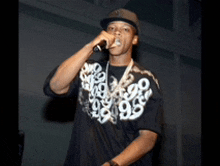 a man singing into a microphone wearing a shirt with numbers on it and a hat