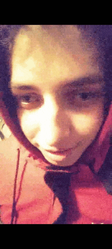 a close up of a person 's face with a red hoodie