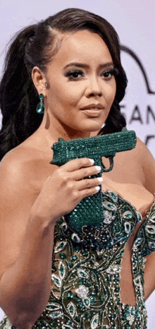 a woman in a green dress holding a green gun