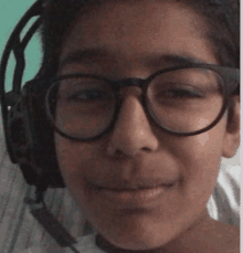 a young boy wearing glasses and headphones is smiling for the camera