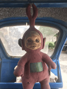 a stuffed teletubbies doll is sitting in the back of a car