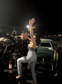 a man and woman are posing for a photo in front of a car