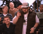 a group of men are standing around a man wearing a hat that says ' r & b ' on it