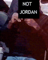a person sitting in a chair with a sign that says not jordan on it