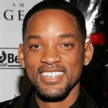 a close up of a man with a beard and earring smiling .