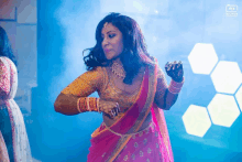 a woman in a pink and gold dress is dancing in front of a blue background that says ' solution ' on the bottom