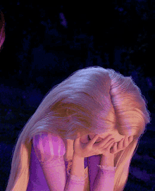 rapunzel covering her face with her hands in a close up