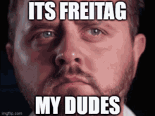 a man with a beard says it 's freitag my dudes in front of his face