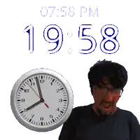 a man stands in front of a wall clock that says 19:58