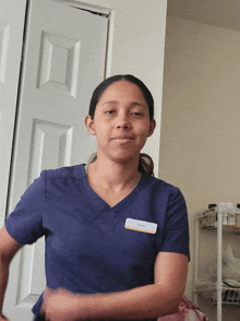 a woman wearing a blue scrub top with a name tag that says ' sandra ' on it